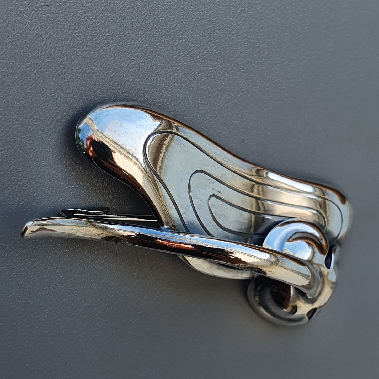 Shiny chrome car door handle with a streamlined, curved design.