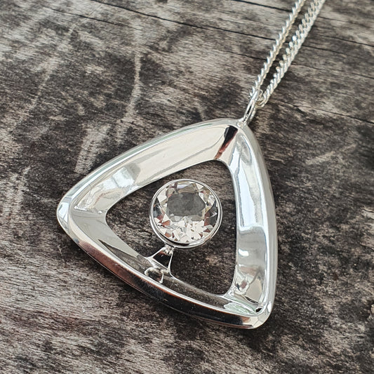 Triangular silver pendant necklace with a clear gemstone in the center.