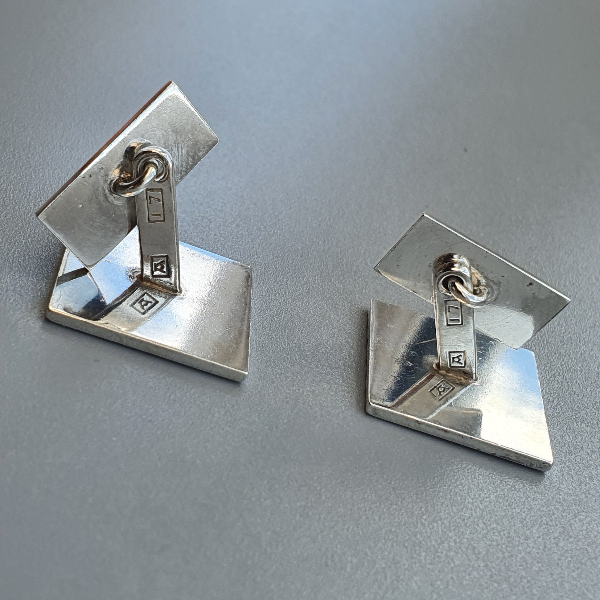 Pair of silver geometric earrings with angular designs.