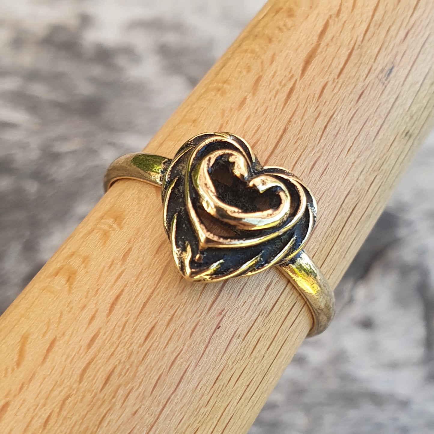 Gold ring featuring a stylized heart design.