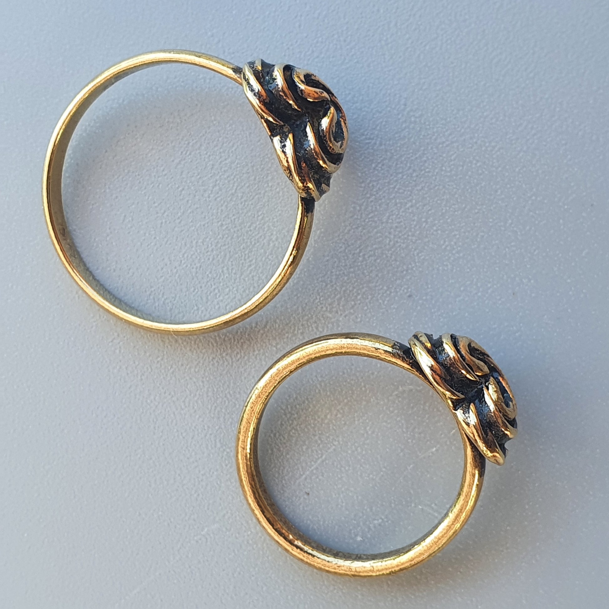 Gold rings with decorative knot-like elements on top.