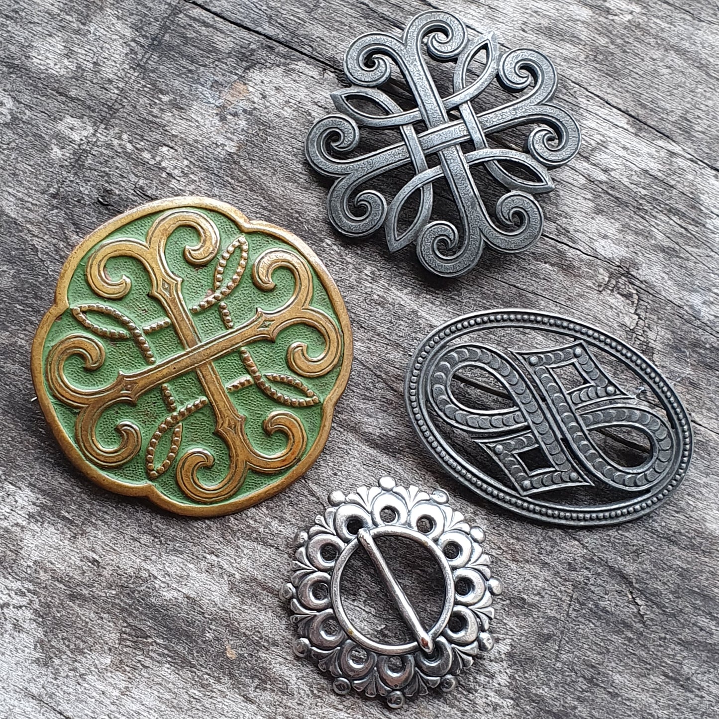 Collection of ornate Celtic-style brooches or pins with intricate knotwork designs.