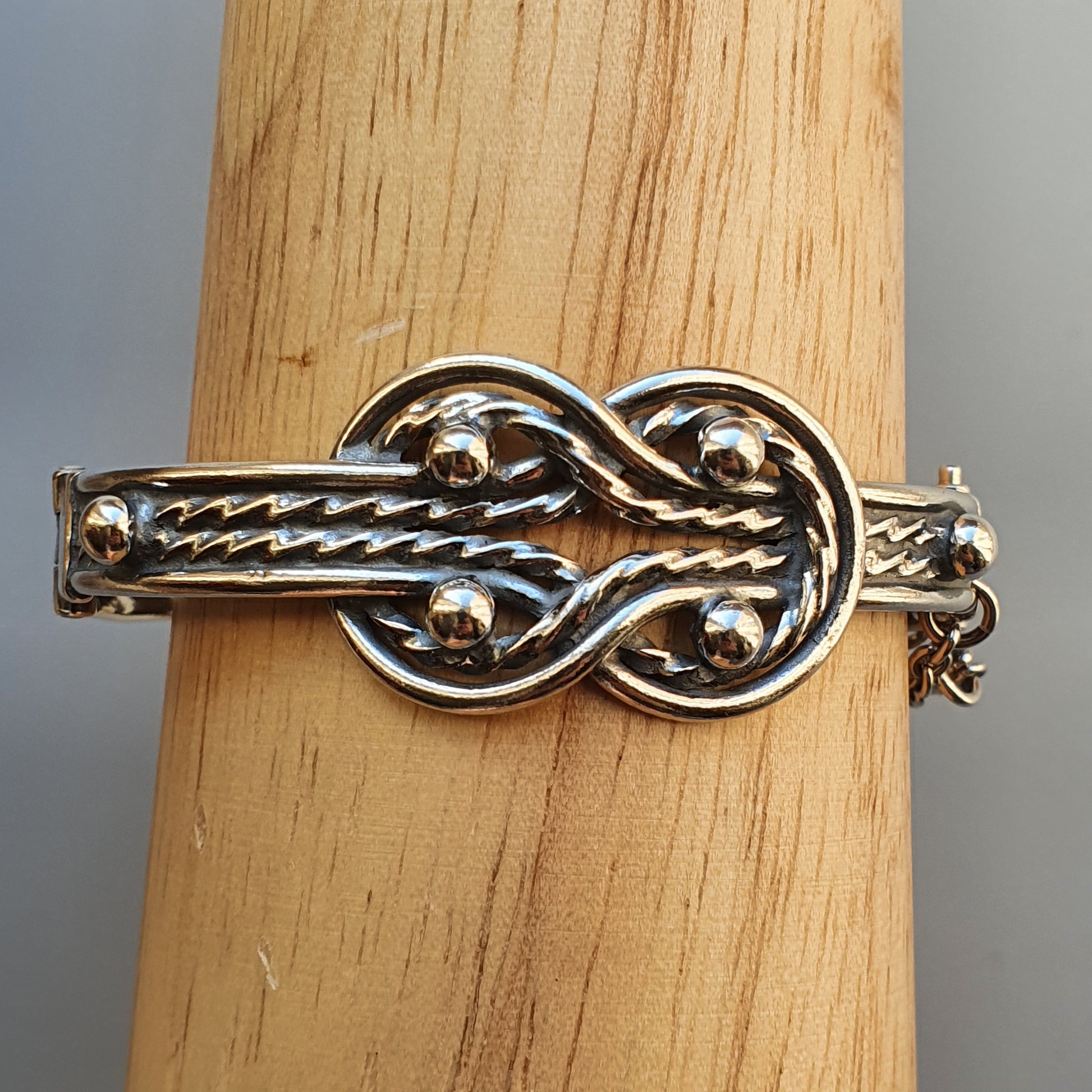 Silver bracelet featuring an intricate knot design.