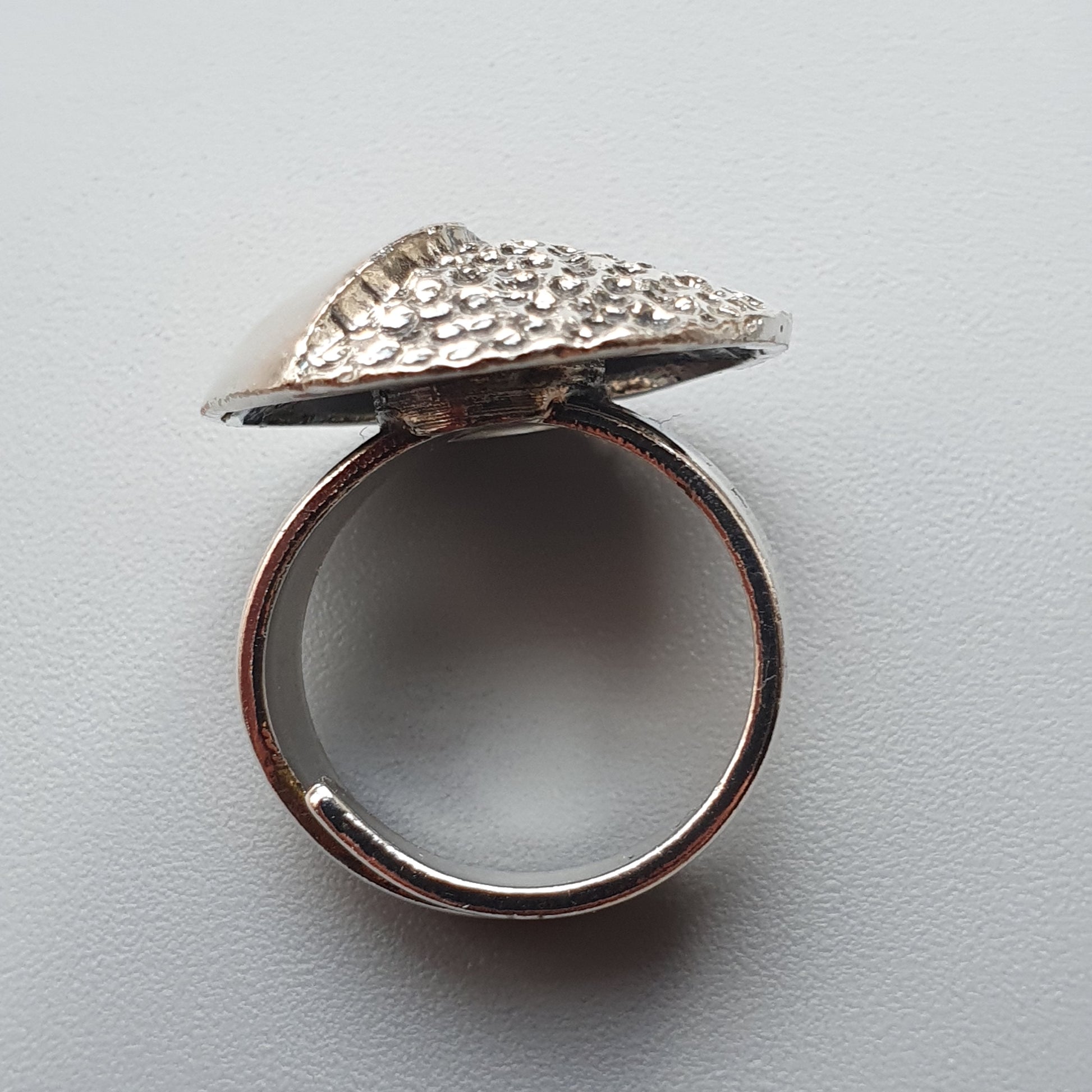 Silver ring with a textured, triangular top resembling a shark fin.