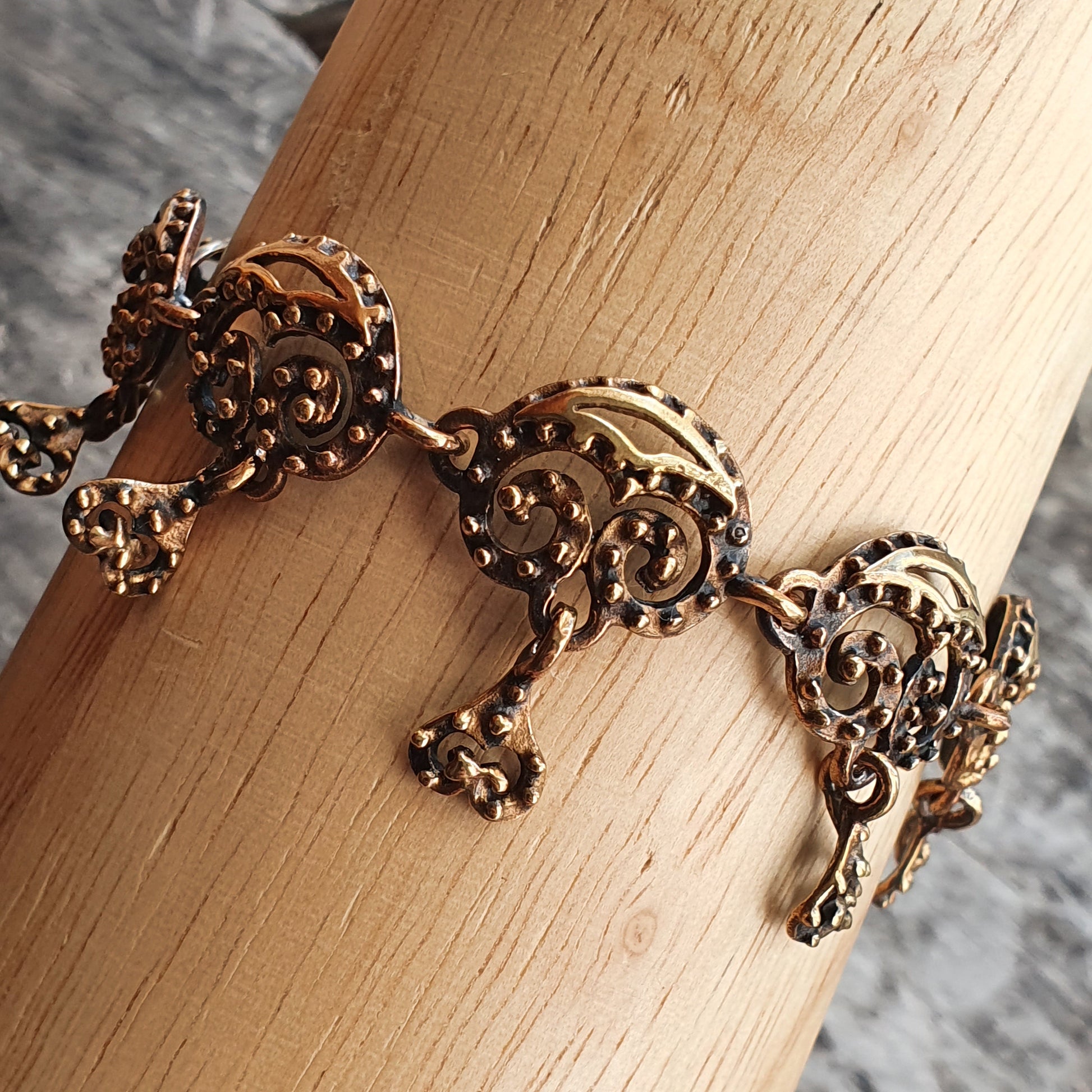 Ornate gold-toned bracelet with intricate filigree elephant designs.