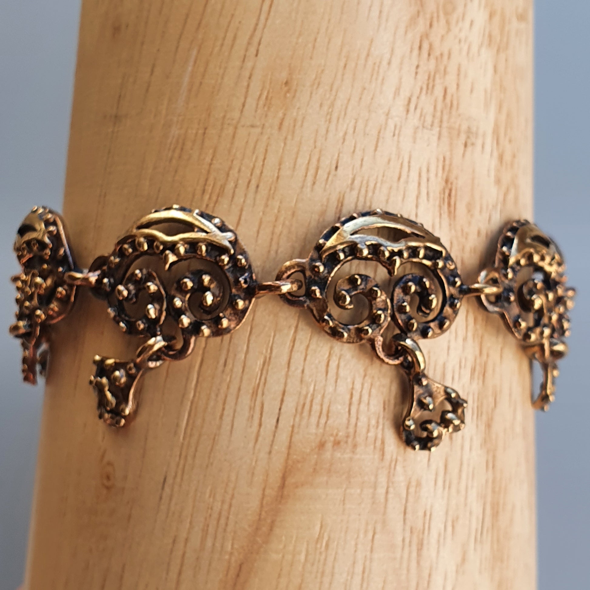 Ornate gold bracelet with intricate elephant-shaped links.