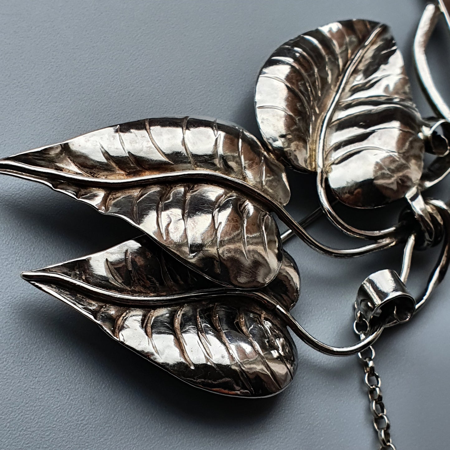 Silver leaf-shaped brooch or pendant with intricate vein detailing.