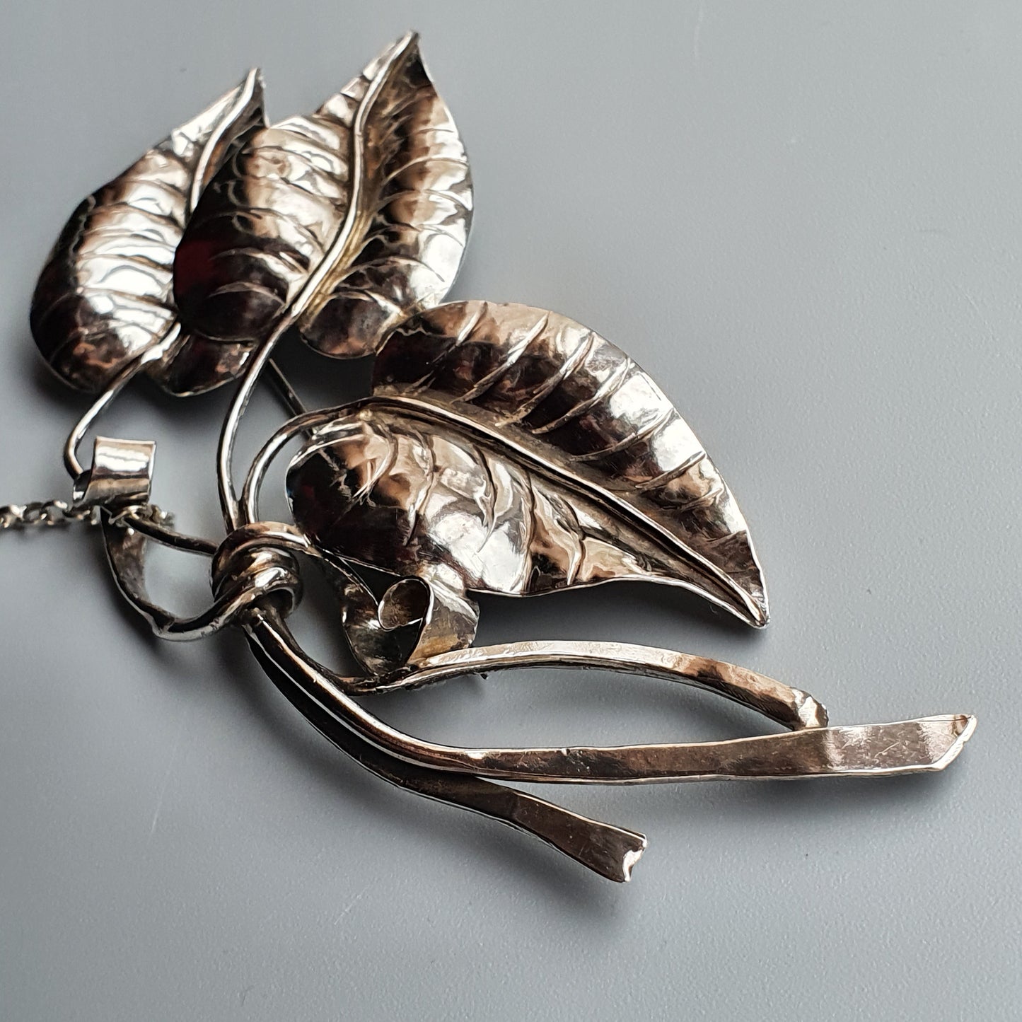 Silver leaf-shaped brooch or pendant with multiple detailed leaves and stems.