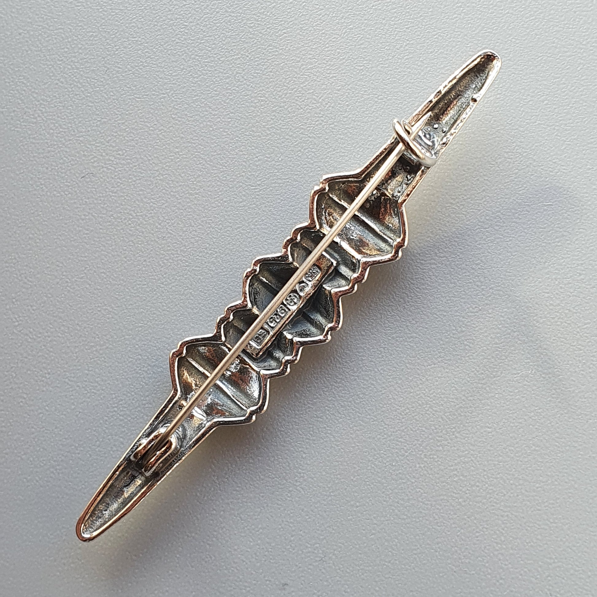 Silver hair clip with an intricate geometric design along its length.