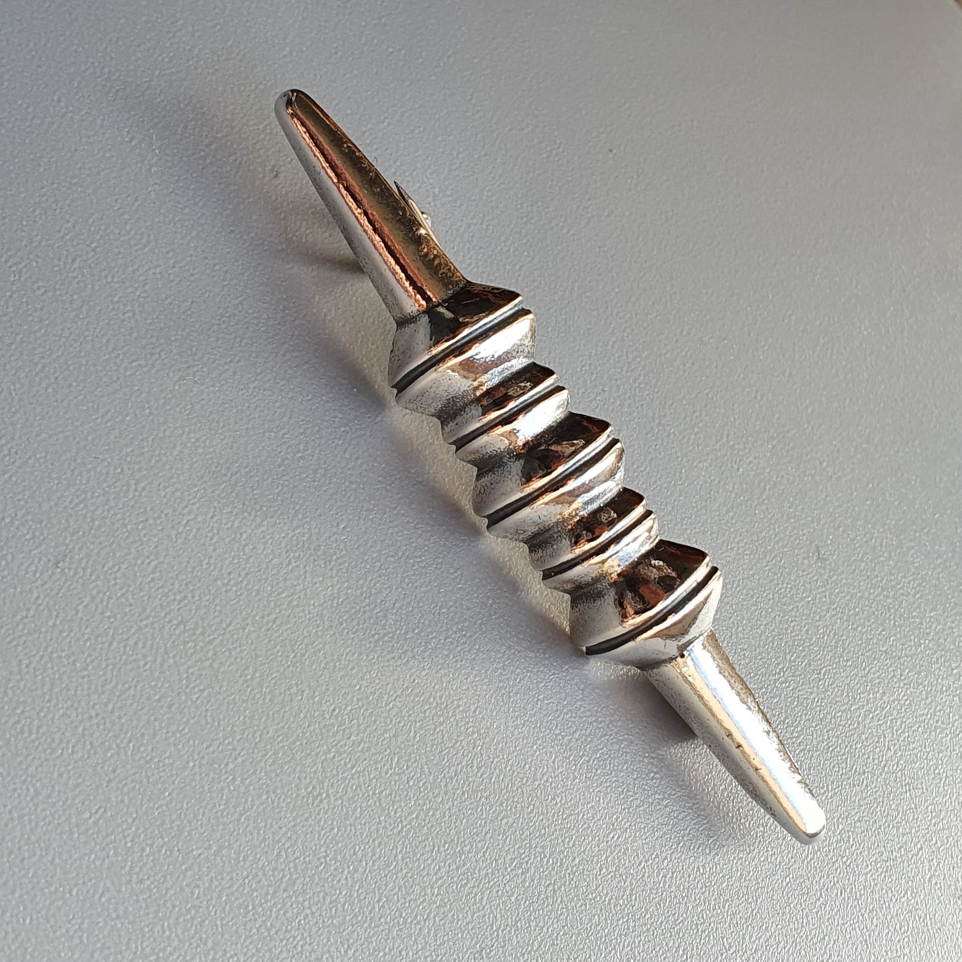 Metal wine bottle pourer with a spiral design and tapered spout.