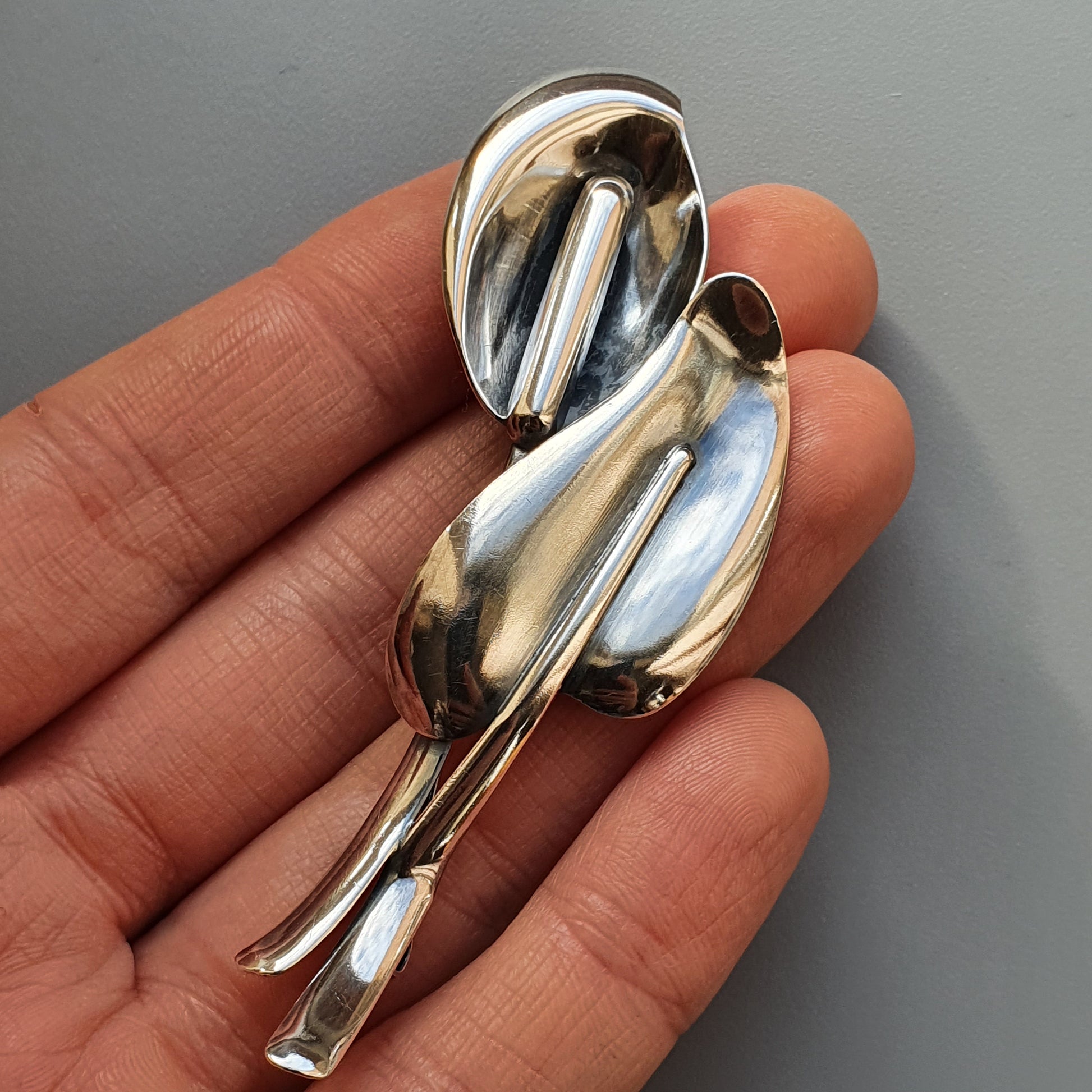 Silver modernist brooch or pin with abstract curved shapes.