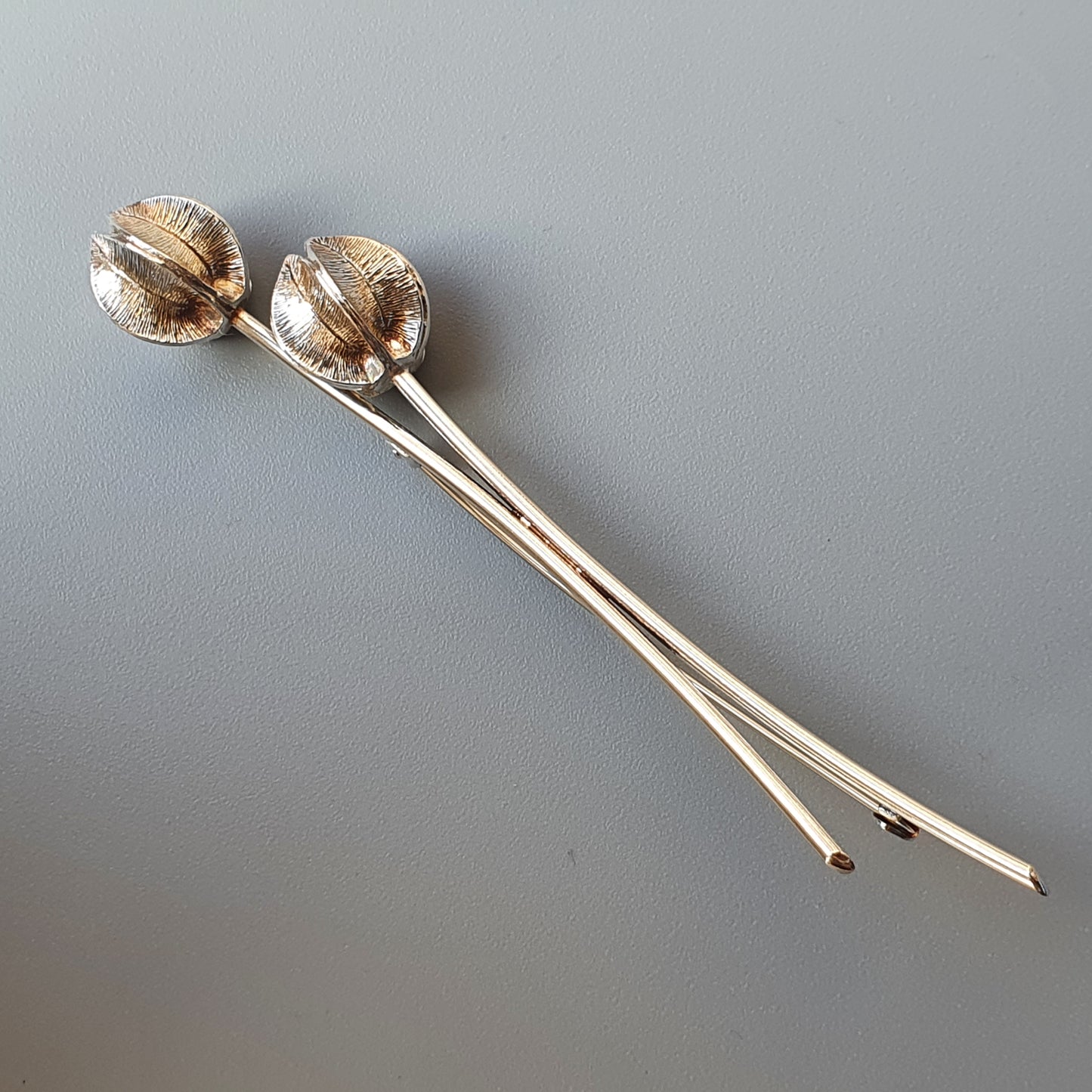 Two decorative hair pins with spherical shell-like tops.