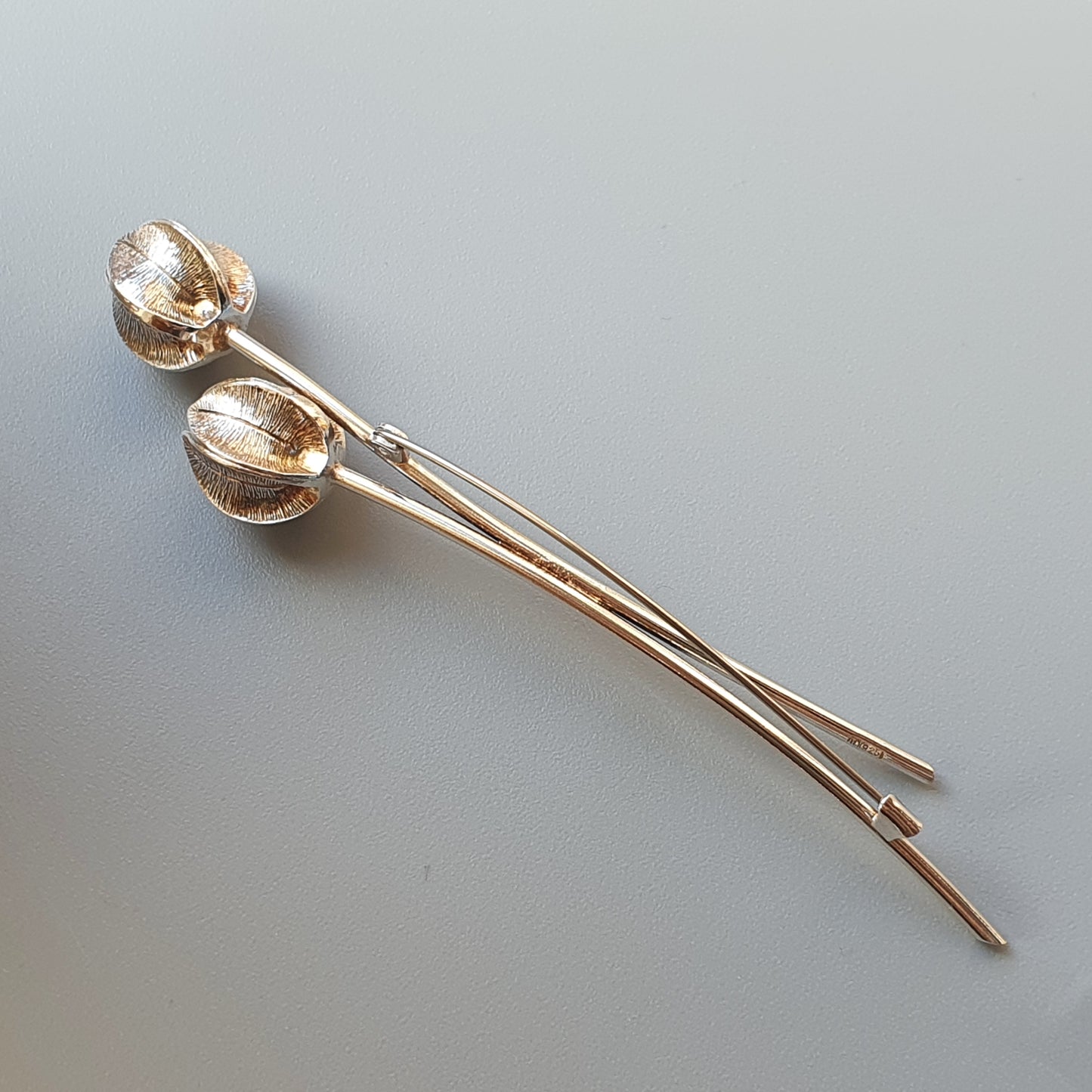 Pair of silver-colored hair pins with spherical decorative ends resembling seed pods.