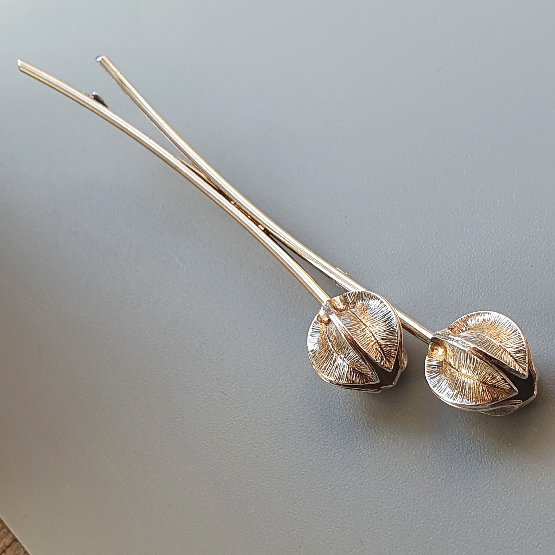 Pair of decorative chopsticks with ornate metal spheres at one end.