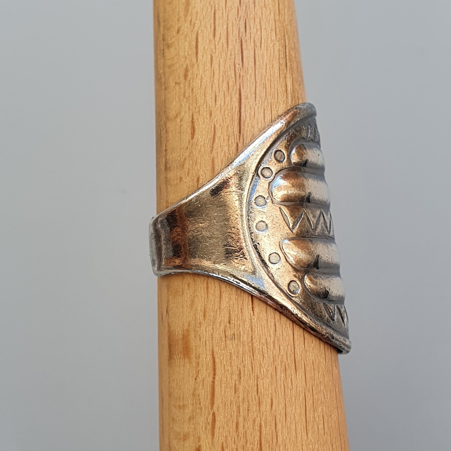 Silver ring with a shark-like design featuring teeth and eyes.