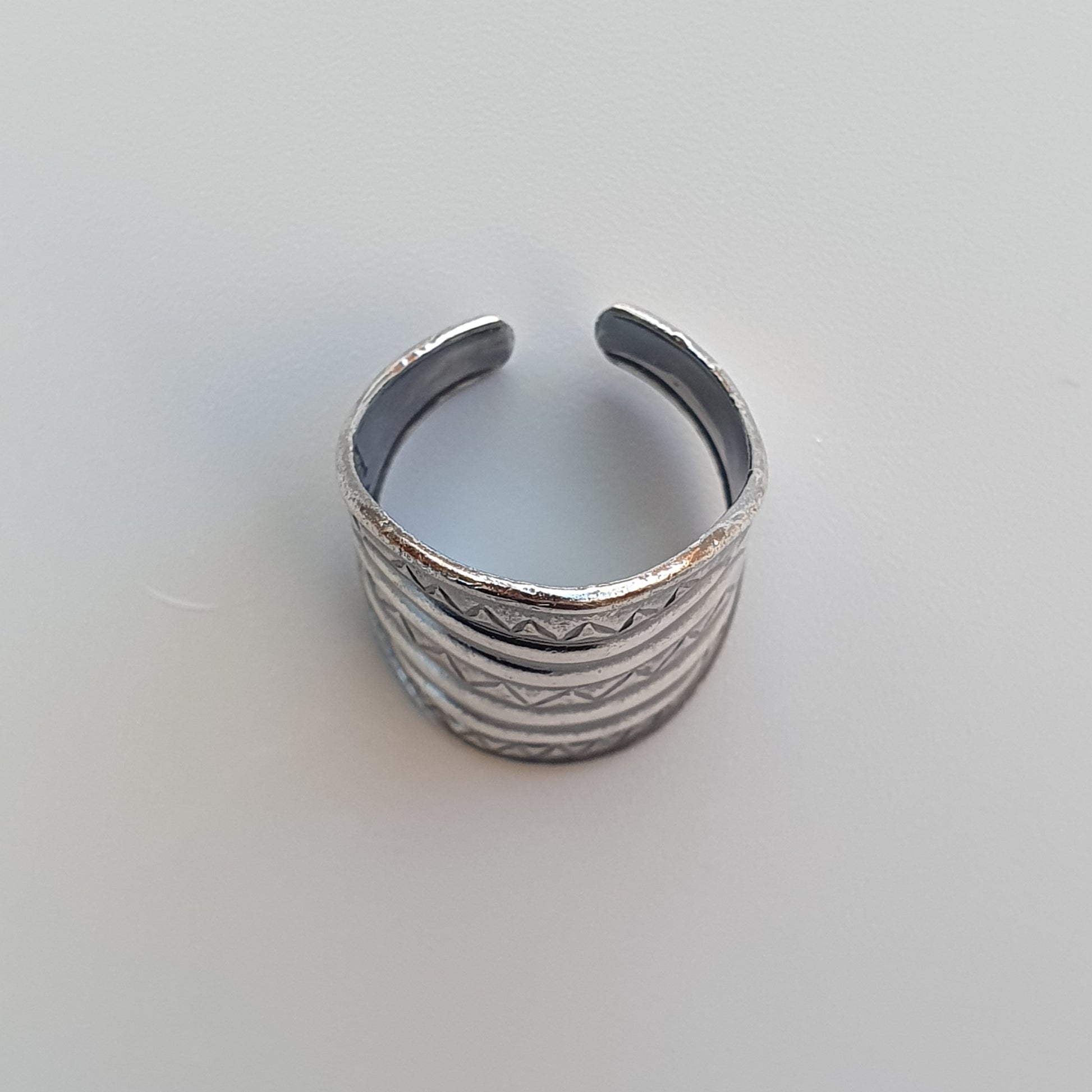 Silver cuff bracelet with engraved wavy patterns.