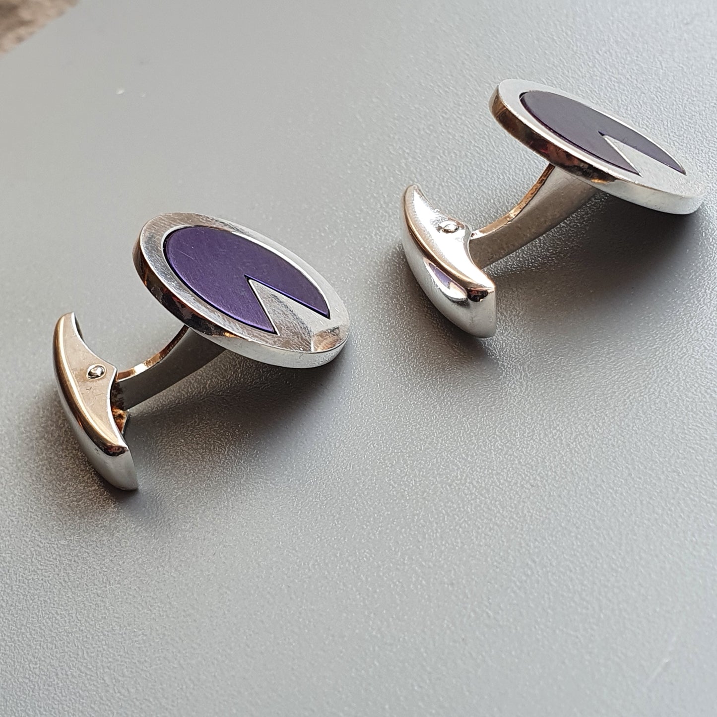 Pair of oval cufflinks with purple and gray enamel centers.