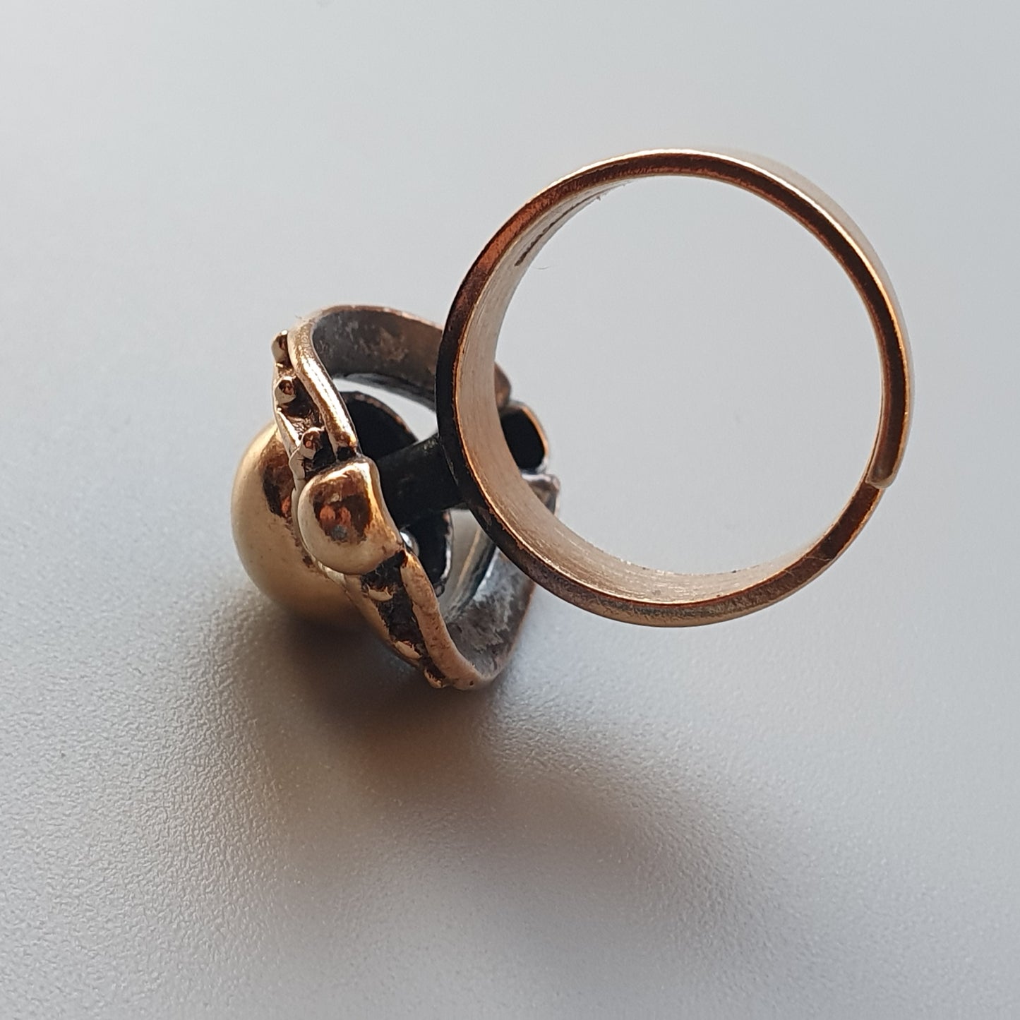 Unusual ring featuring a miniature human skull design with a large circular hoop.