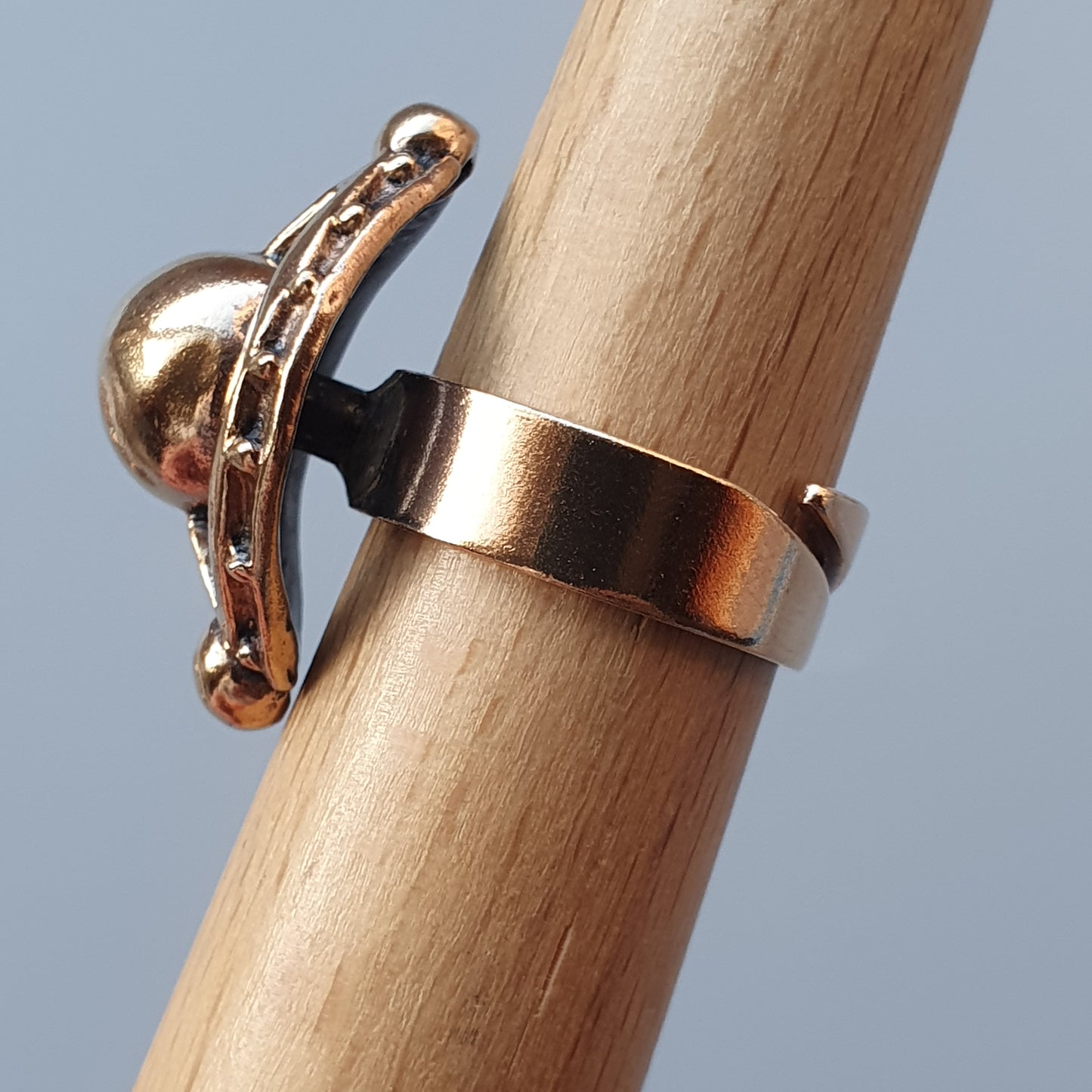 Gold-colored ring with a small dolphin-shaped charm attached.