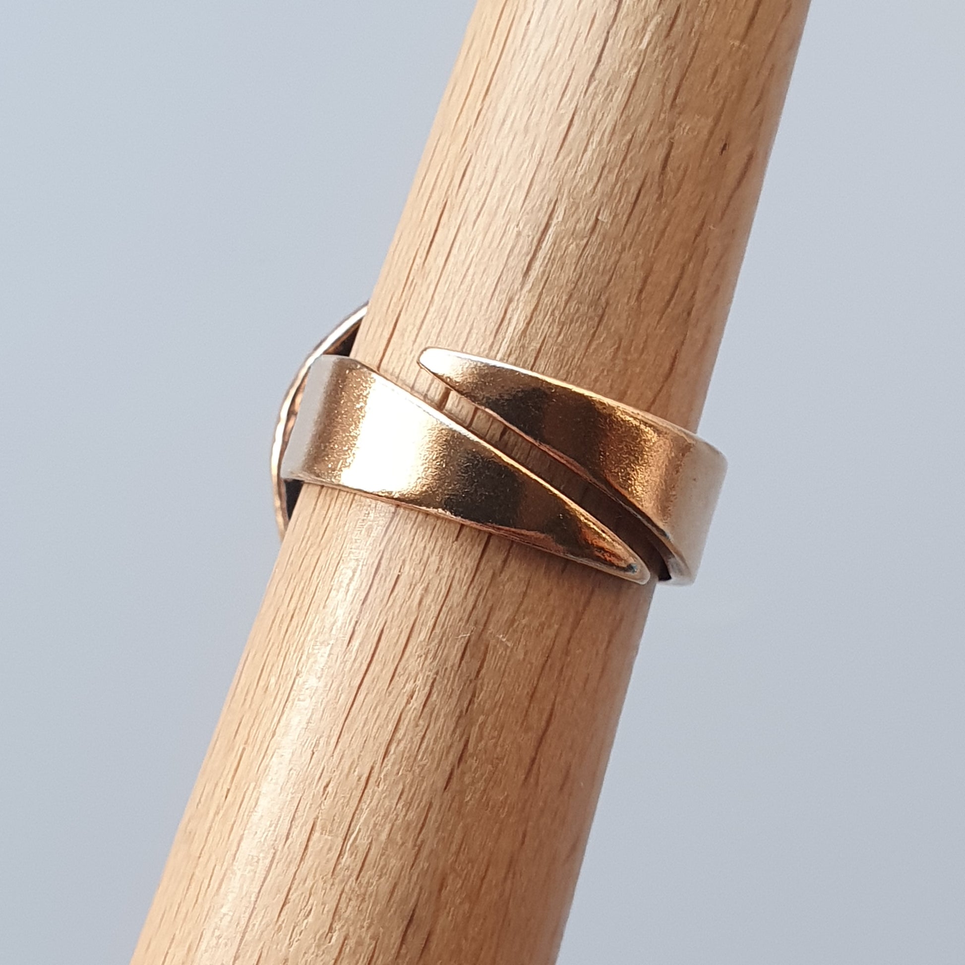 Gold-toned metal ring with an overlapping twisted design.