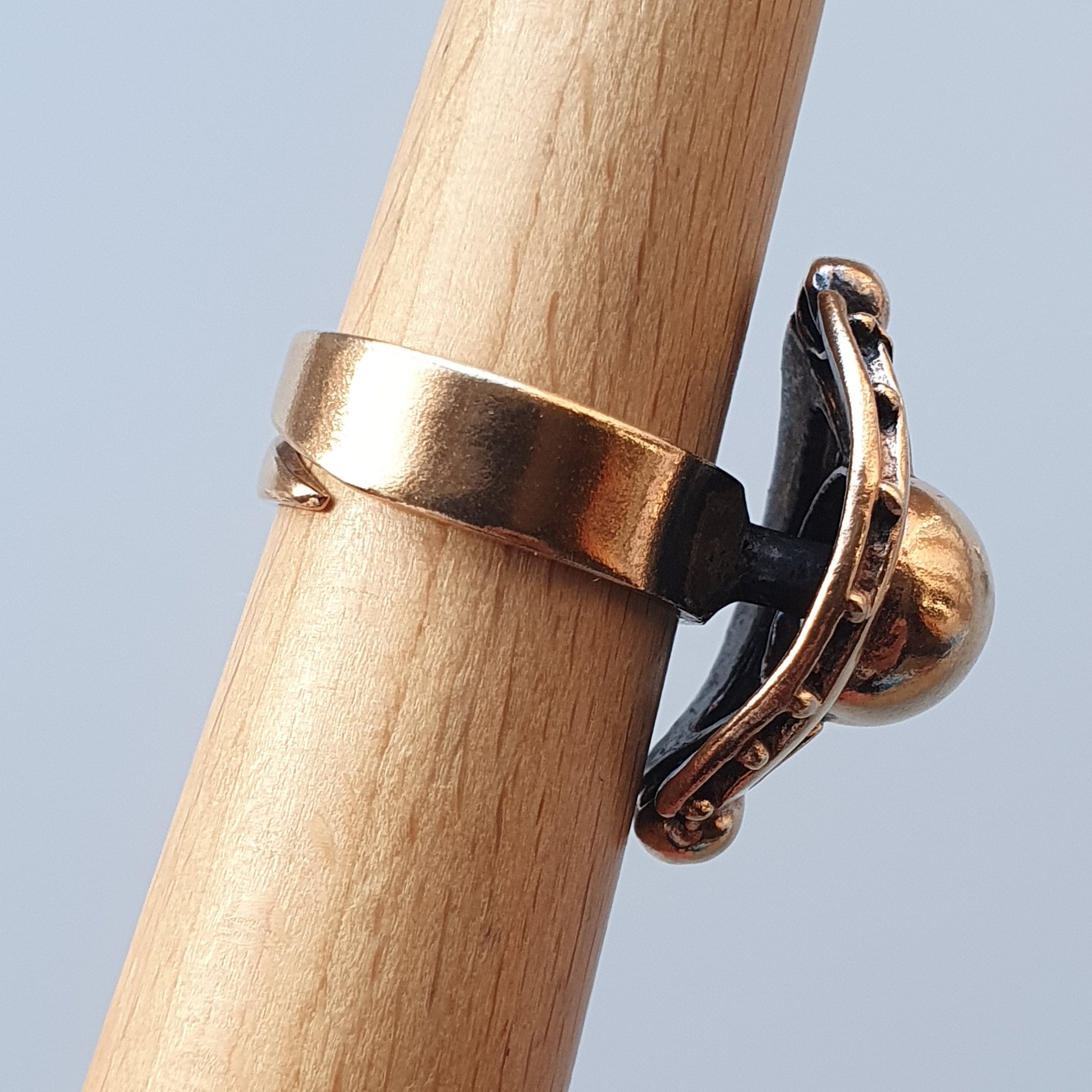 Gold ring with a horseshoe-shaped design attached to the band.