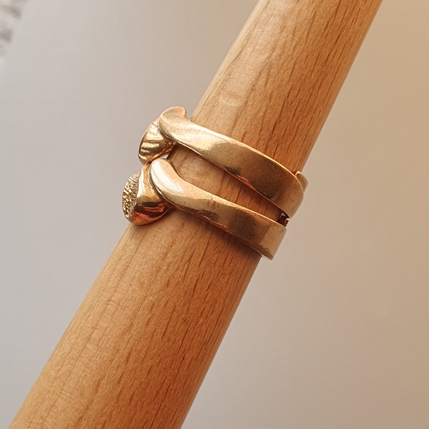 Gold ring with a unique spiral design featuring small decorative elements.