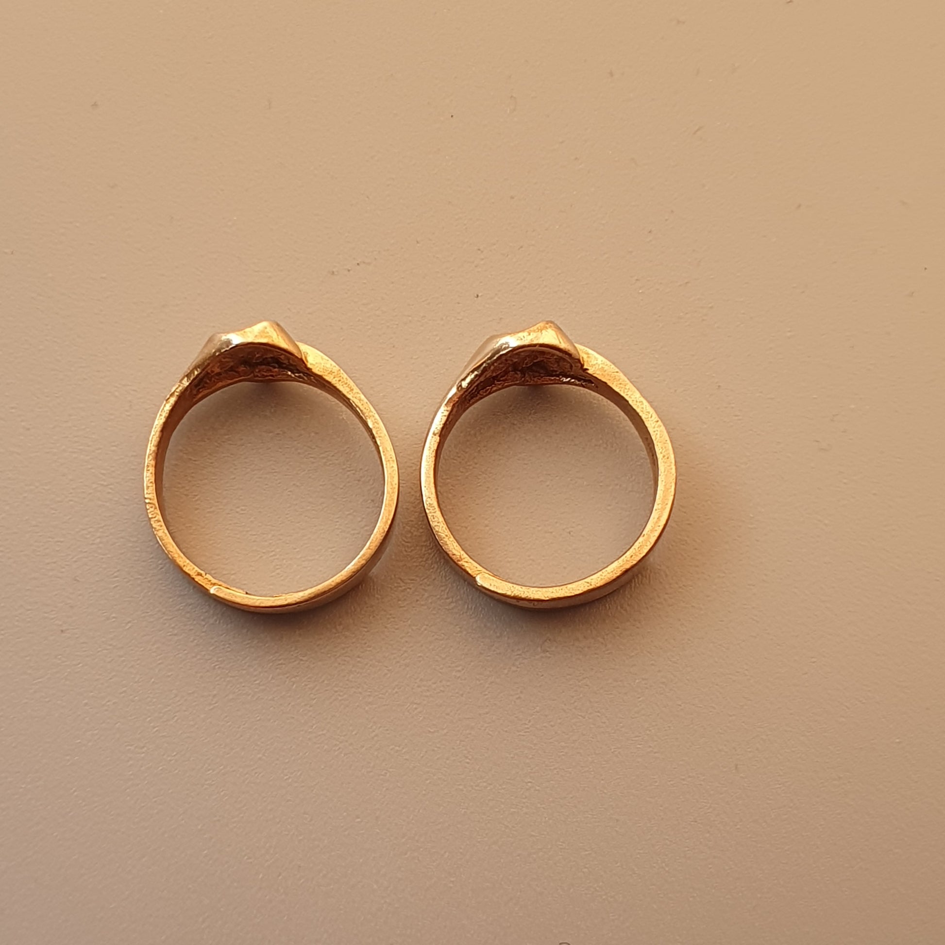 Pair of gold-colored rings with a textured or hammered surface.