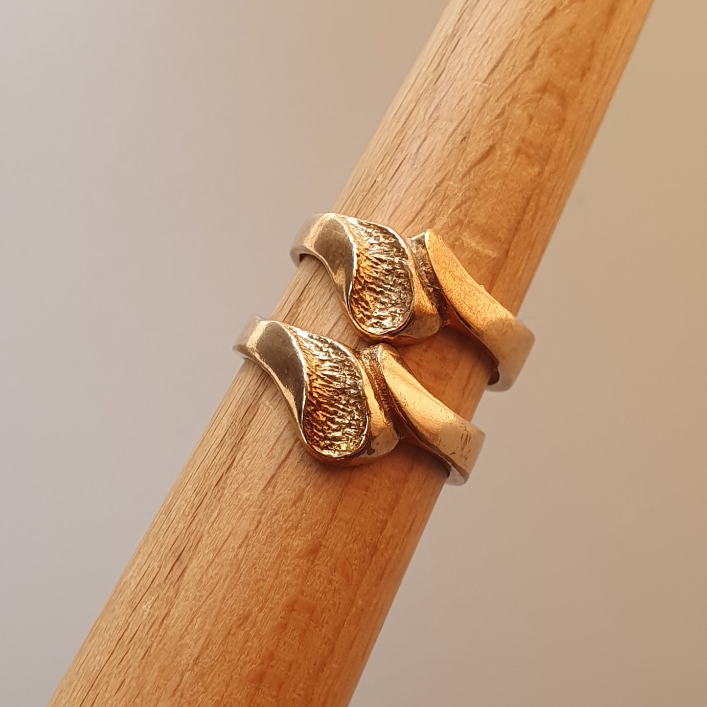 Gold ring with two teardrop-shaped elements side by side.