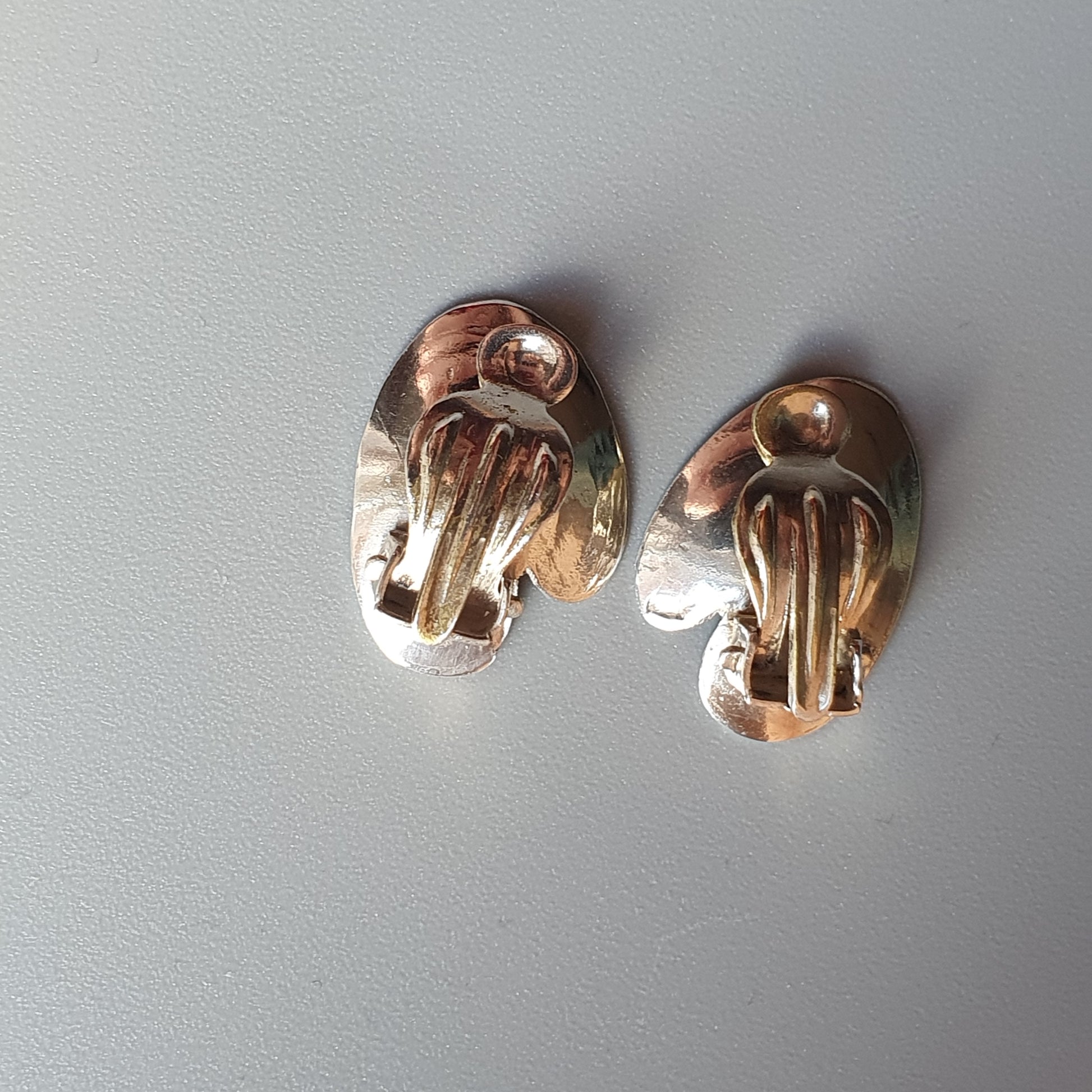 Pair of metallic clip-on earrings with a jellyfish-like design.