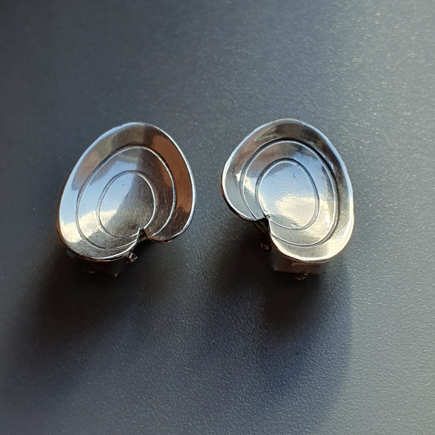 Pair of silver spiral-shaped earrings or studs.