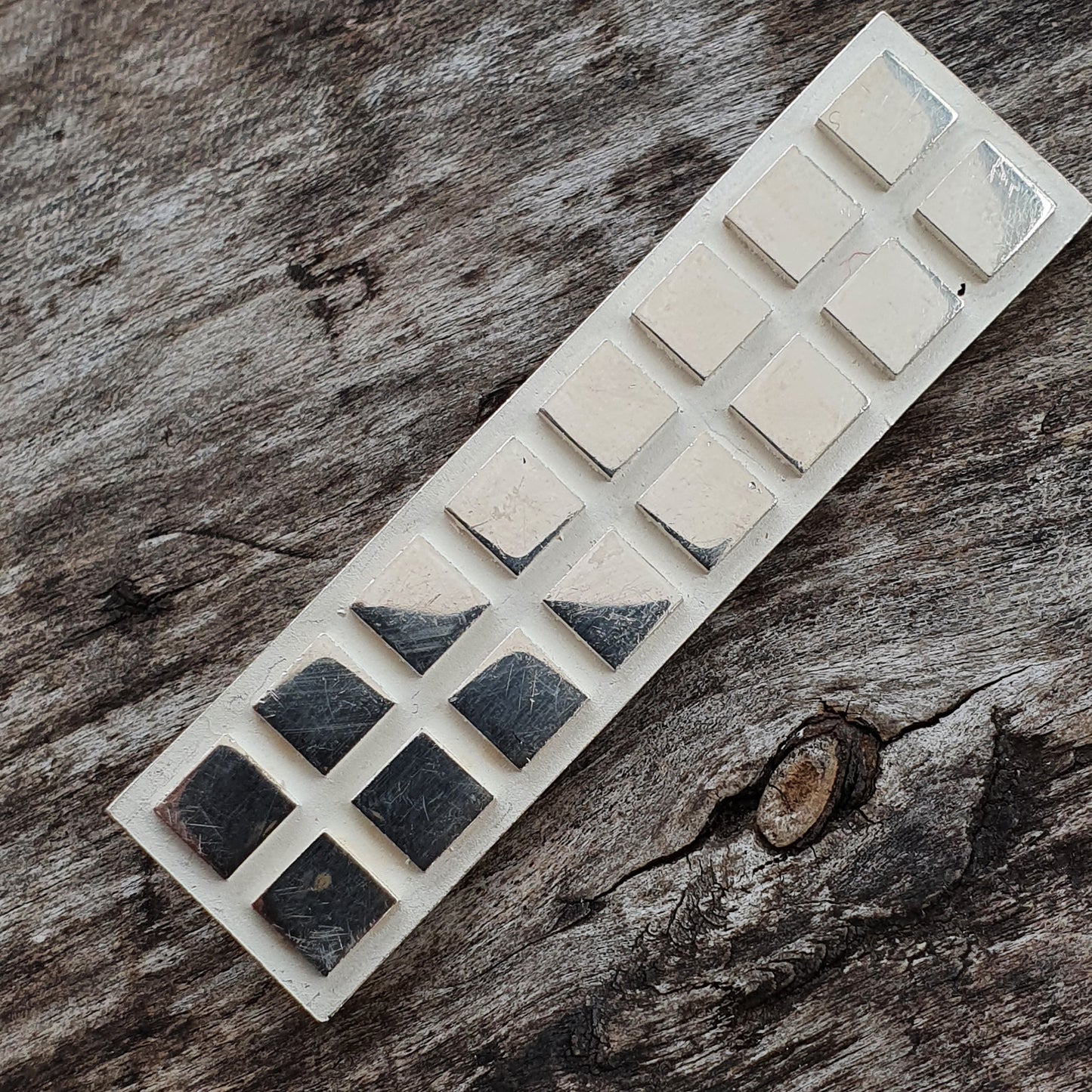 Gradient-filled squares on a minimalist rectangular silver brooch design