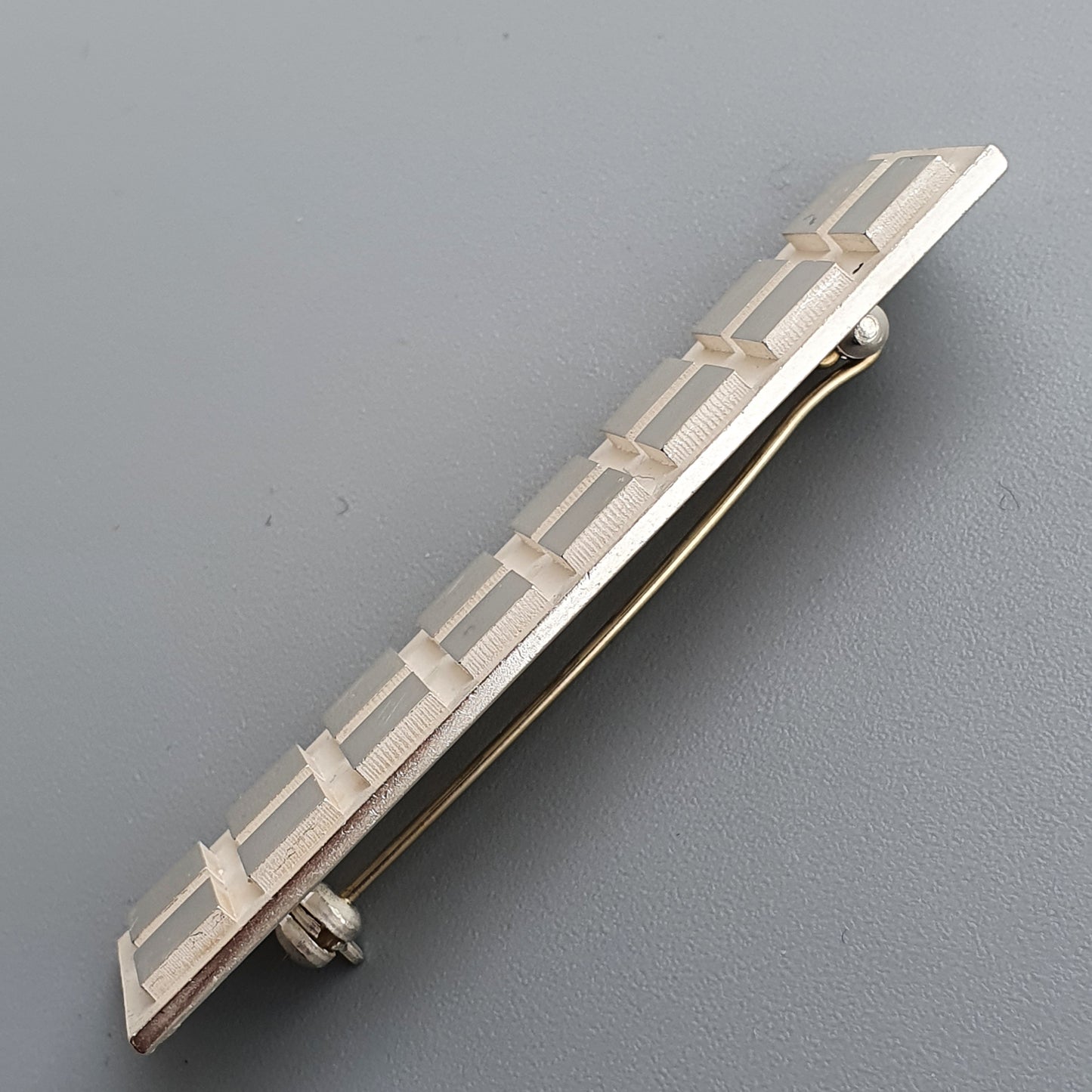 Elongated silver tie clip featuring geometric pattern for a minimalist rectangular silver brooch