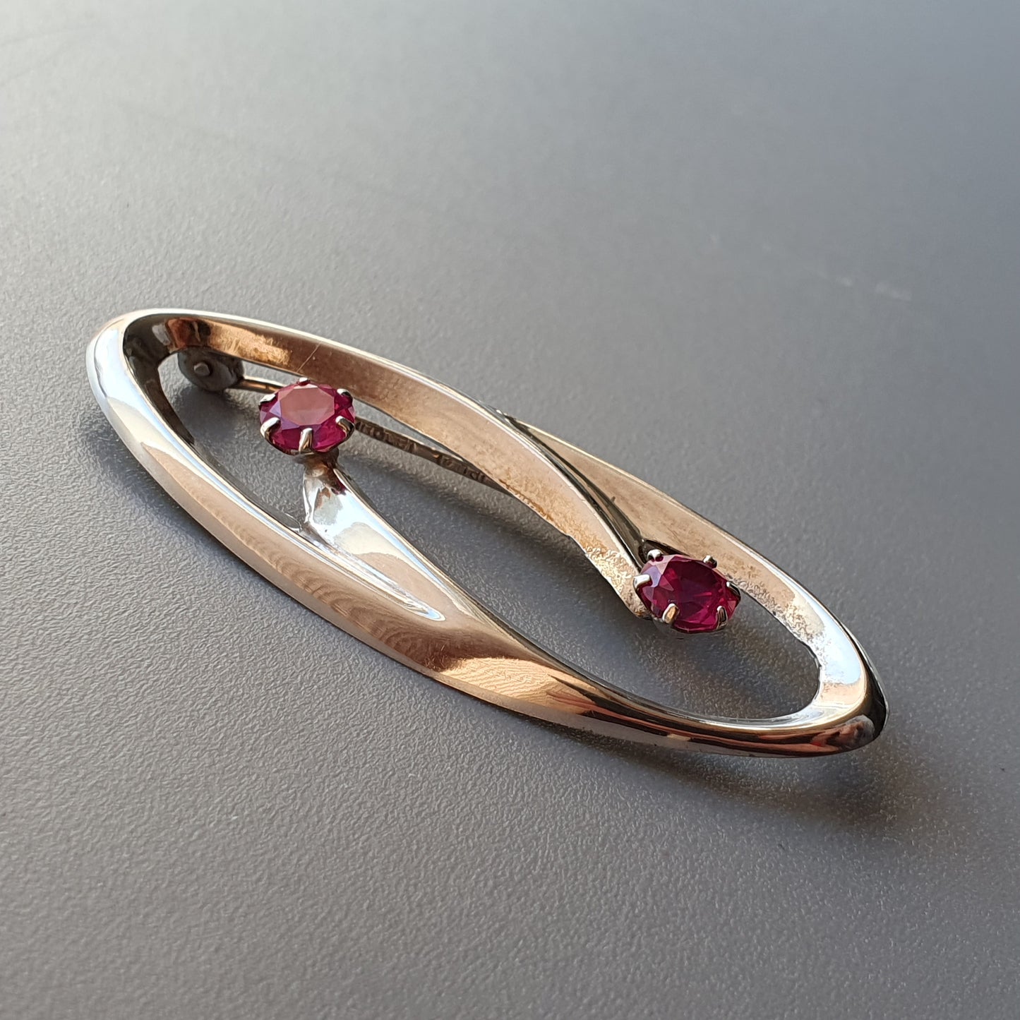 Elegant gold ring with two small ruby gemstones set in a twisted design.