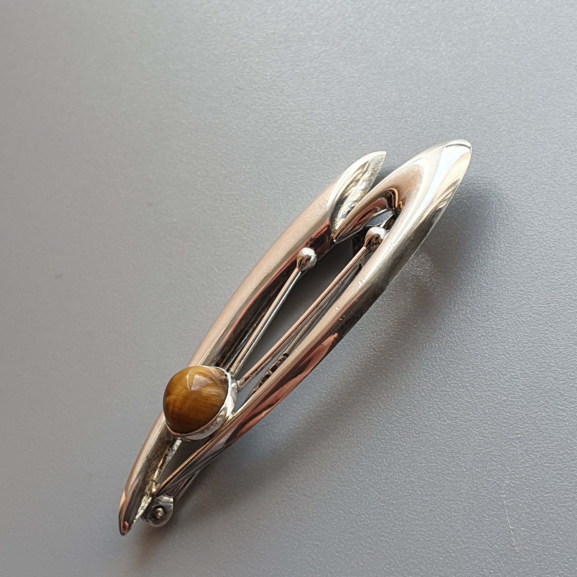 Silver hair clip with a small amber-colored bead or stone accent.